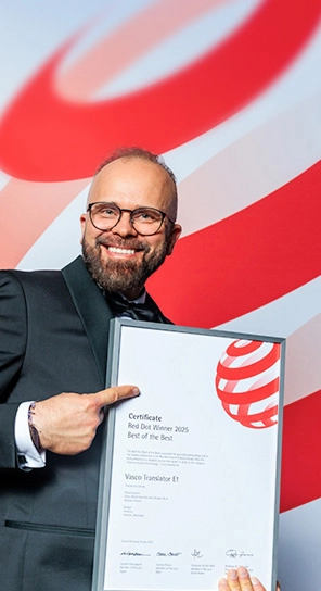 Administrerende direktøren for Vasco Electronics holder Red Dot-prisen i hånden og præsenterer de prisvindende enheder.