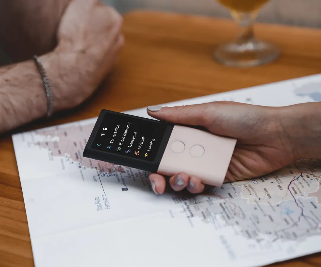 Nærbillede af en hånd, der holder en oversætter over et bord med et kort på.